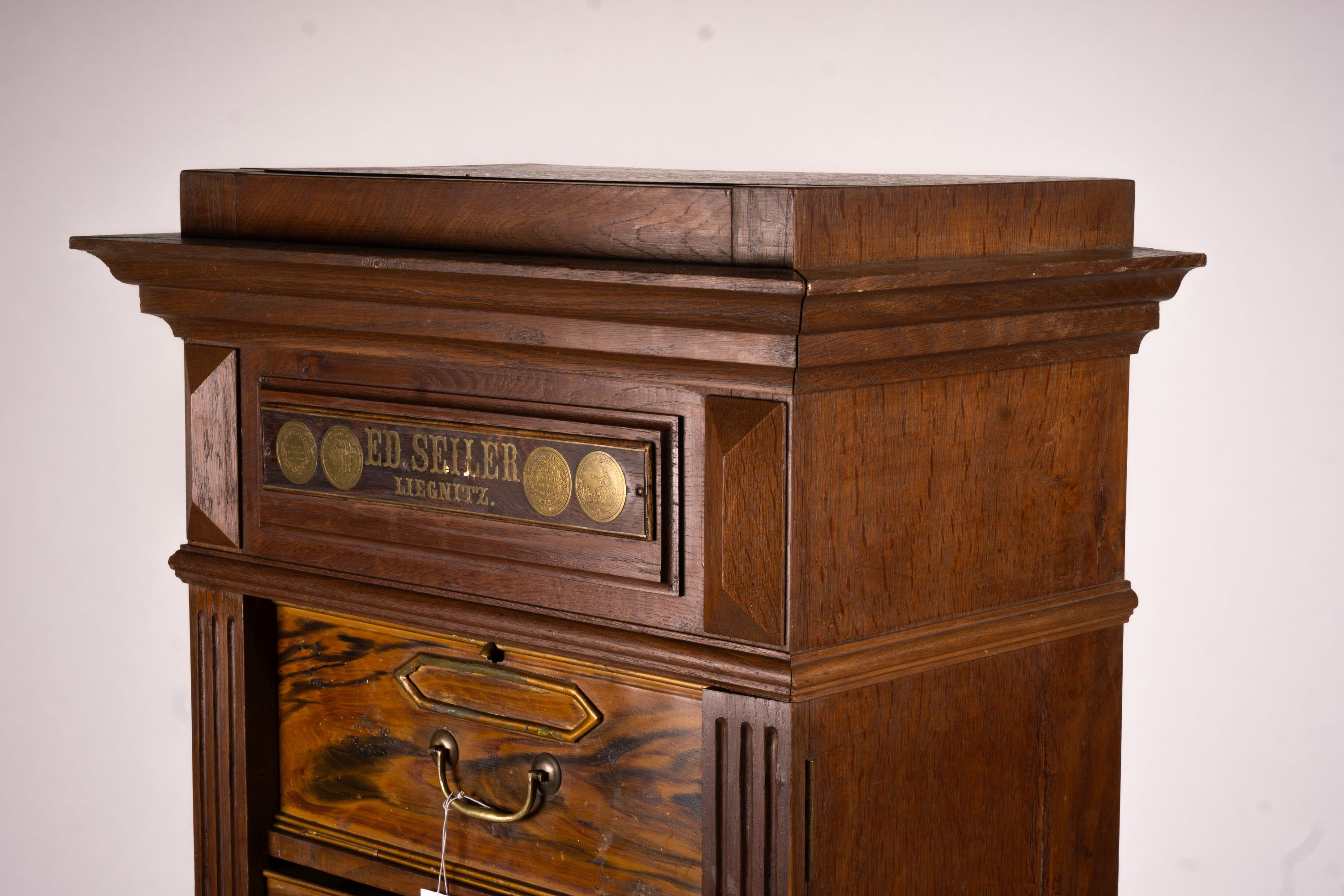 A late 19th / early 20th century oak and simulated walnut shop storage chest / filing cabinet, labelled Ed Seiler, width 57cm, depth 34cm, height 152cm